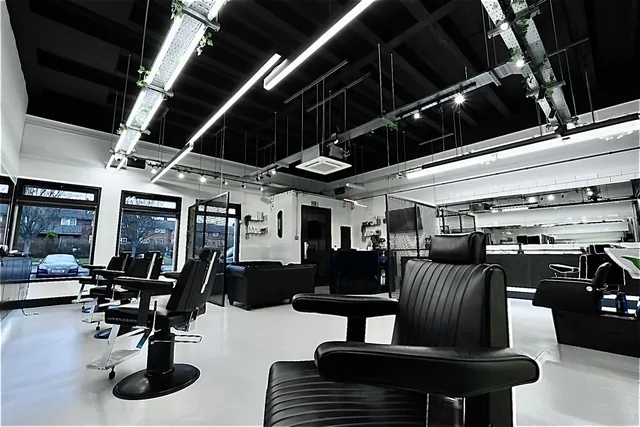 The main floor: barber chairs facing a long mirrored counter, with the front windows behind.